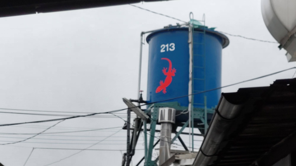 赤いヤモリのマークが描かれた豊島屋酒造の青いタンク